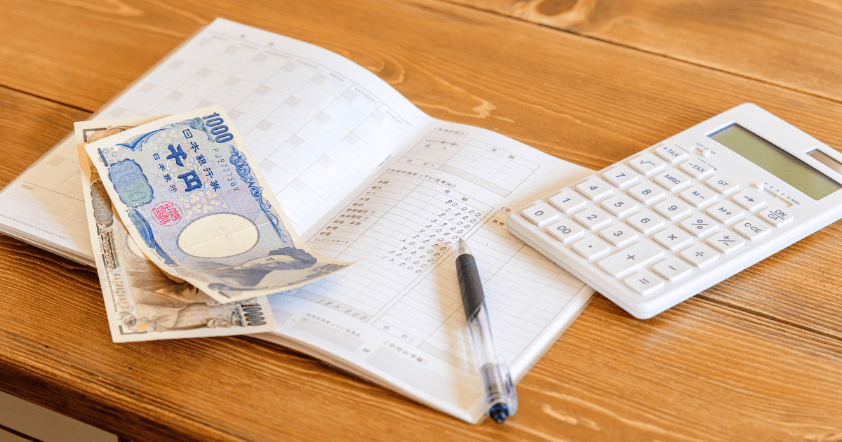 ノートと電卓で資金計画を立てるイメージ